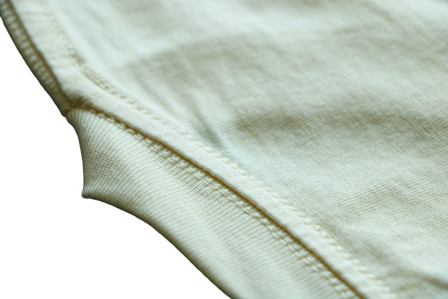 Close-up of a bone white t-shirt with a focus on texture and stitching.