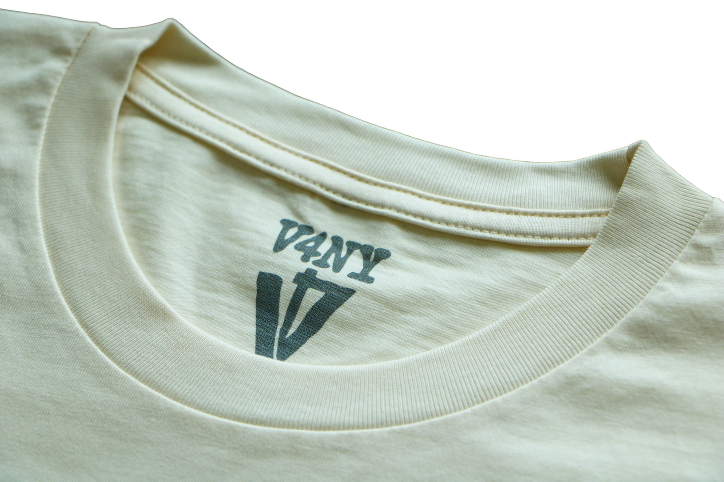 Close-up of a bone white t-shirt with a V4NY logo in the collar