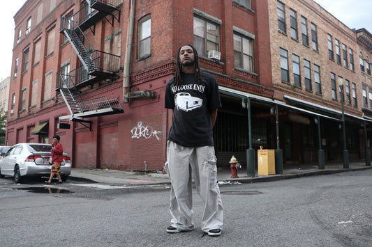 Model wearing V4's 'No Loose Ends' t-shirt while standing on city street