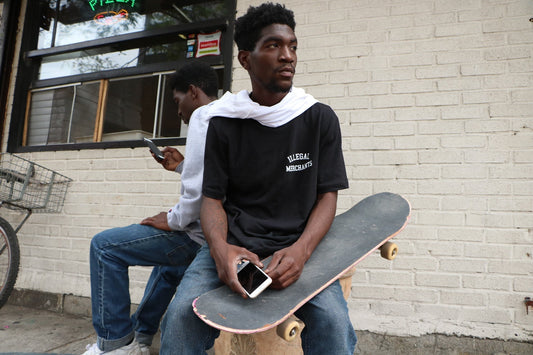 NYC skateboarder in sneakers and hoodie hanging out at a street spot